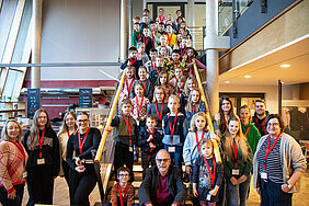 Gruppenfoto vom „Kind-kommt-mit-Tag“ mit allen Kindern und mitwirkenden Beschäftigten der Bezirksverwaltung in der Cafeteria des Bezirksrathauses.