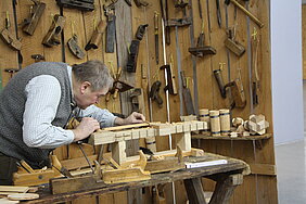 Museumsbüttner Hans Grau an der Werkbank.